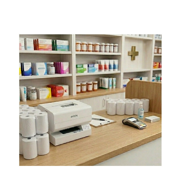 Rouleaux de papier utilisés avec une imprimante Epson TM-J sur un comptoir de pharmacie