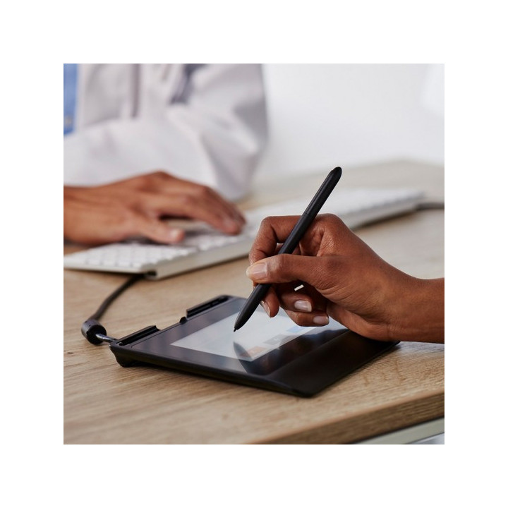 photo d'une main qui signe avec le stylet sur la tablette Wacom STU 540